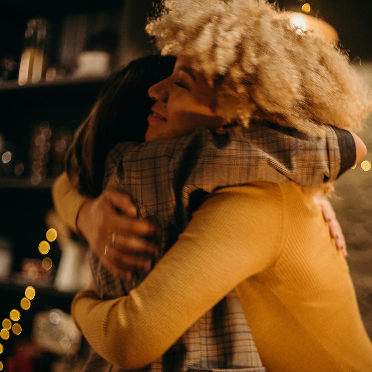 Two young adult friends hugging and smiling